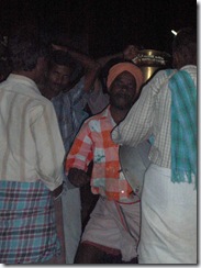 Villager dancing to the drums as people carry puja materials